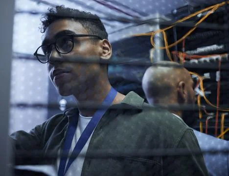 Sorting out the server. Cropped shot of two male IT support agents working to Stock Photos