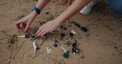 Sorting Various Keys in an Outdoor Setting to Organize Different Items and Stock Footage 318519268