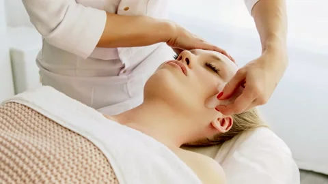 Сosmetologist makes lifting modeling face massage with Gua Sha scraper Stock Footage 171805835