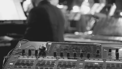 A sound control panel in foreground and a blurred musician in background Video stock 306338838