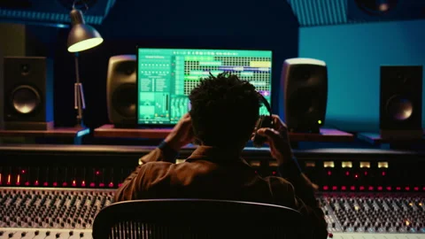 Sound designer editing tracks by adjusting volume levels with panel board knobs Stock Footage 270438113