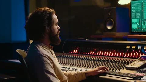Sound designer processing and mixing tunes in control room Stock Photos