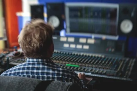 Sound editor engineer working at studio with mixing panel, mixing music and s Stock Photos
