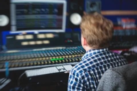 Sound editor engineer working at studio with mixing panel, mixing music and s Stock Photos