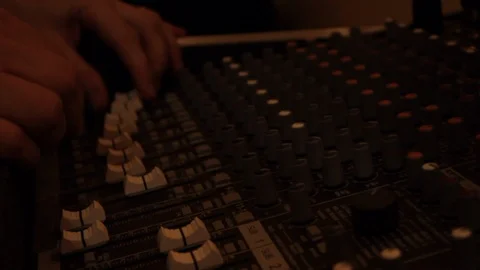 Sound engineer adjust controls on sound board during a music show Stock Footage 107629045