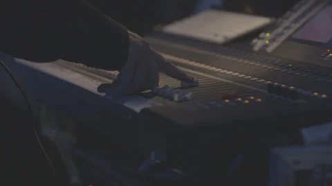 Sound engineer adjusting controls on sound desk Stock Footage 98694594