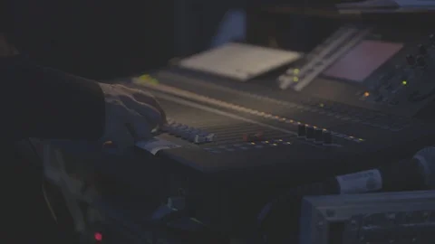 Sound engineer adjusting controls on sound desk Stock Footage 98694939