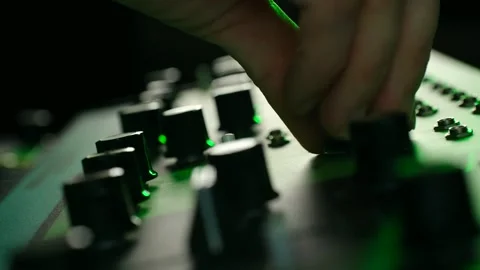 Sound engineer adjusting mixer knobs in a music studio Stock-Footage 337830914
