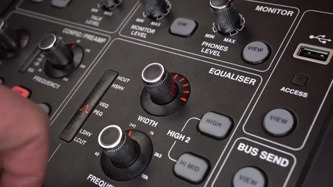 A sound engineer adjusts frequencies on a digital audio mixer. The man presses Stock Footage 233042999