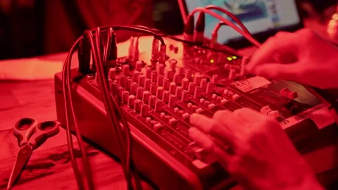 The sound engineer adjusts the sound quality at a party with a red light using a Stock Footage 201876881