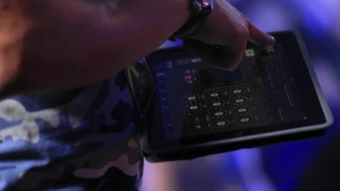 Sound engineer adjusts the sound using the program on the tablet. Stock Footage 99496869