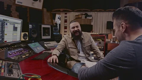 Sound engineer and musicians working in boutique recording studio Stock Footage 74354847