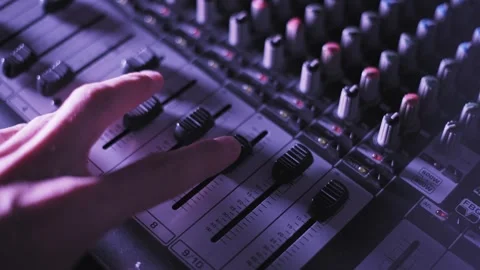 Sound Engineer Hand Adjusting Mixer Faders in Dark Studio Video stock 329608061
