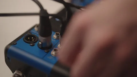 Sound engineer hands cleaning audio mixing console knobs, maintaining Stockbeeldmateriaal 325712306