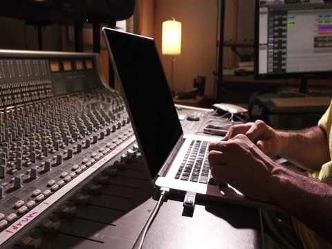 Sound Engineer on Mixing Console Using Laptop Computer Stock Footage 74657548