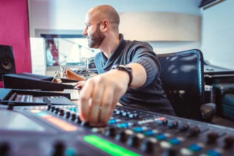 Sound engineer mixing a song in his studio Stock Photos