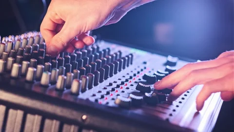 Sound Engineer Moves Faders Up and Down on Audio Mixer in Neon Light Close-Up Stock Footage 260548301