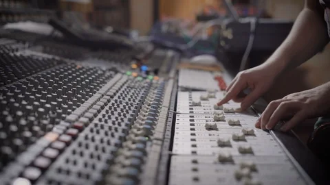 Sound engineer is moving levers of a multitrack mixing console in the control Stock Footage 86694127