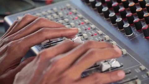 Sound engineer operating mixing console close up, audio levels and knobs, Stock Footage 344011807