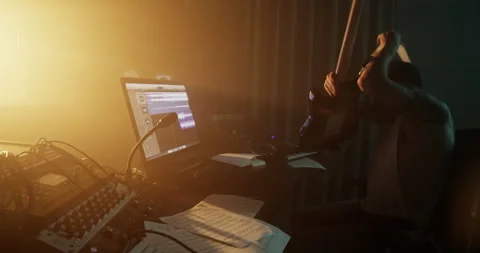 Sound engineer playing guitar and using computer in studio Video stock 249913112
