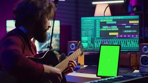 Sound engineer practices playing acoustic guitar using learning app tutorial Stock Footage 268373960