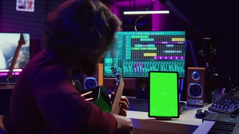 Sound engineer practices playing acoustic guitar using learning app tutorial Stock Footage 268508105