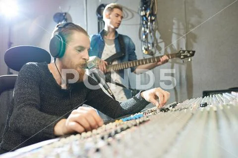 Sound engineer recording guitar performance in studio Stock Photos