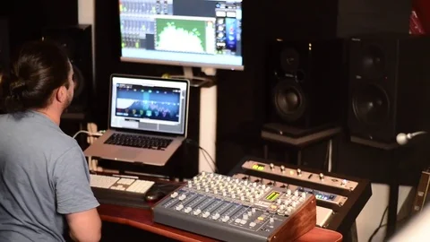 Sound engineer in recording studio using laptop at the mixing desk. Vídeos de archivo 79686217