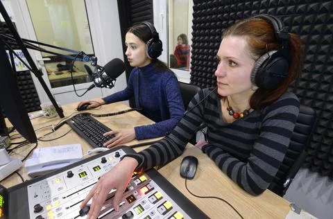 Sound engineer regulating level of sound with studio sound mixer at a radio Stock Photos