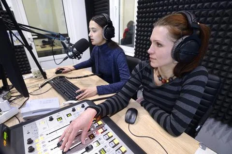 Sound engineer regulating level of sound with studio sound mixer at a radio s Stock Photos