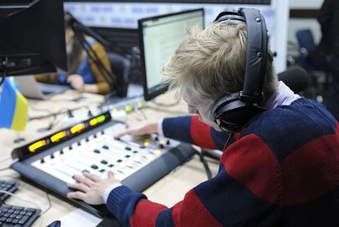 Sound engineer regulating level of sound with studio sound mixer at a radio s Stock Photos