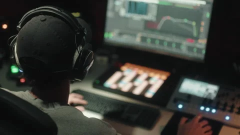 Sound engineer seen seated from behind uses the computer to mix audio music 스톡 동영상 171856650