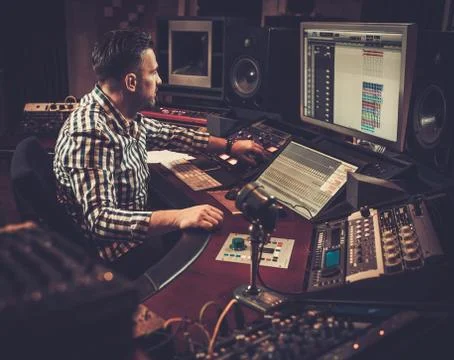 Sound engineer working at mixing panel in the boutique recording studio. 스톡 사진