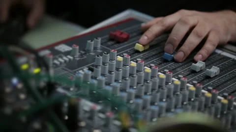 Sound engineer's hand on the mixing console at the event. Stock Footage 129704724