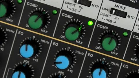 Sound engineers hand turning compression knob of a mixing board - CU Stock Footage 220241267