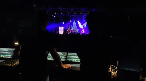 Sound engineers on mixer look to the stage during live concert Stock Footage