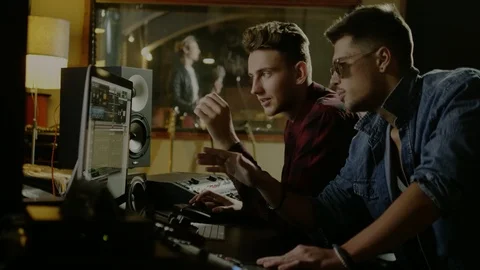 Sound engineers working in garage recording studio Stock Footage 100643180