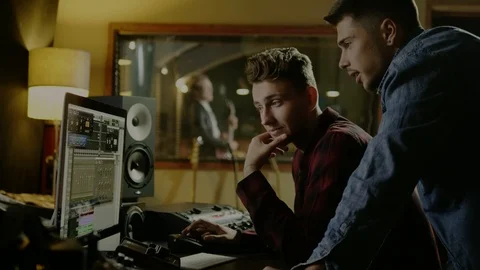 Sound engineers working in garage recording studio Stock Footage 101517382