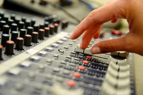 Sound mixer. Close up of hand using slider on mix pult. Stock Photos