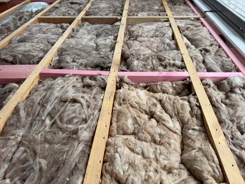 Sound proofing thermal efficiency wool being installed in a timber floor Stock Photos