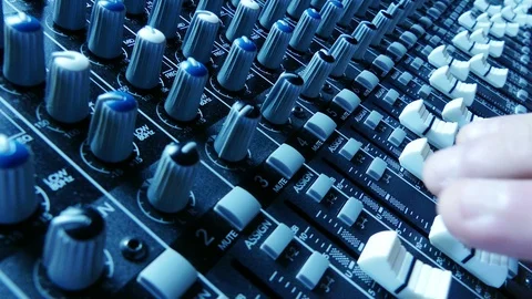 Sound technician hands working on audio mixer faders and knobs Vidéo 87314842