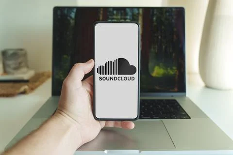 Soundcloud application logo on smartphone screen in front of laptop Stock Photos