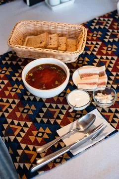 Soup and Bread with Bacon on Patterned Tablecloth Foto stock