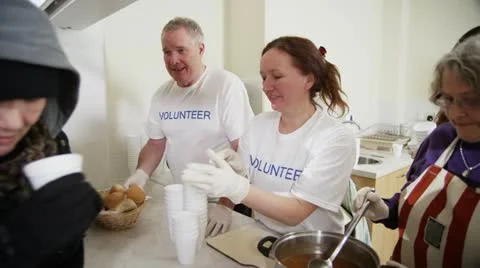 Soup kitchen volunteers help to feed the homeless Stock Footage 20594502