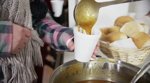 Soup kitchen volunteers help to feed the homeless Stock Footage 20602295