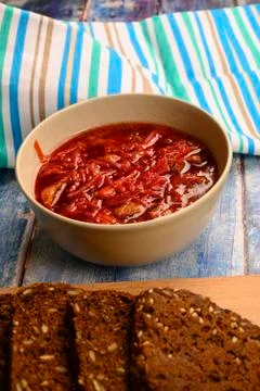 The soup in the plate on the table. Sliced grain bread. Lunch in rustic style Stock Photos