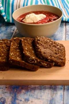 The soup in the plate on the table. Sliced grain bread. Lunch in rustic style Stock Photos
