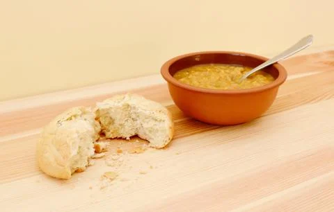 Soup served with a torn crusty bread roll Stock Photos