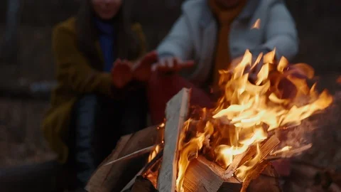 Сouple warming their hands by the fire Видео 98967556