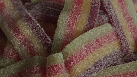Sour belts candy texture rotating macro. Candy and sweets. Unhealthy food Stock Footage 283876180